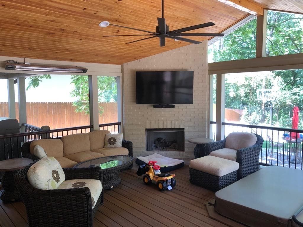 A living room with a couch , chairs , a fireplace and a flat screen tv.