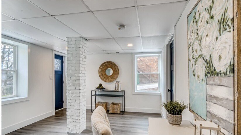 A living room with a couch , table and a painting on the wall.