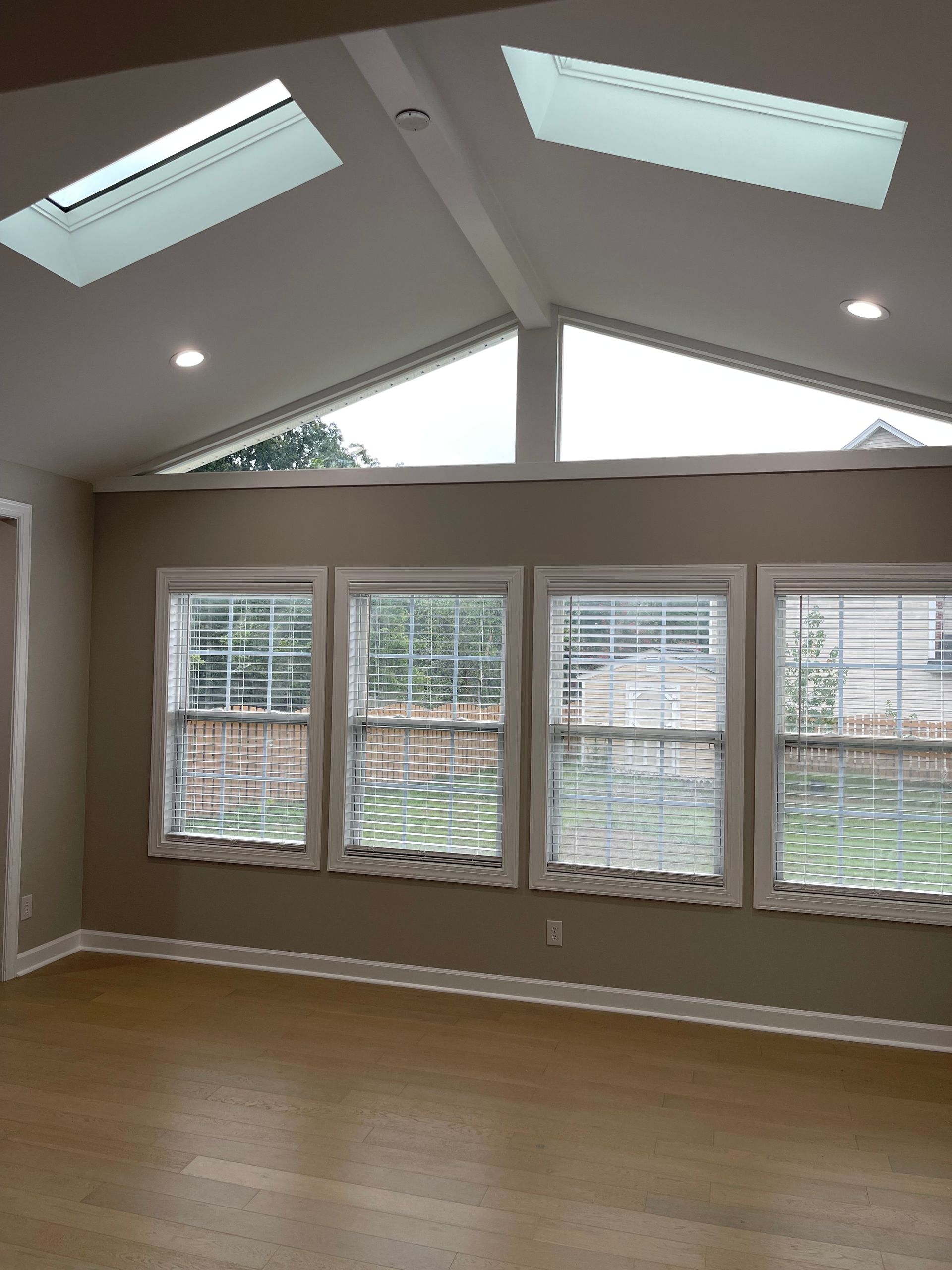An empty room with a lot of windows and a skylight.