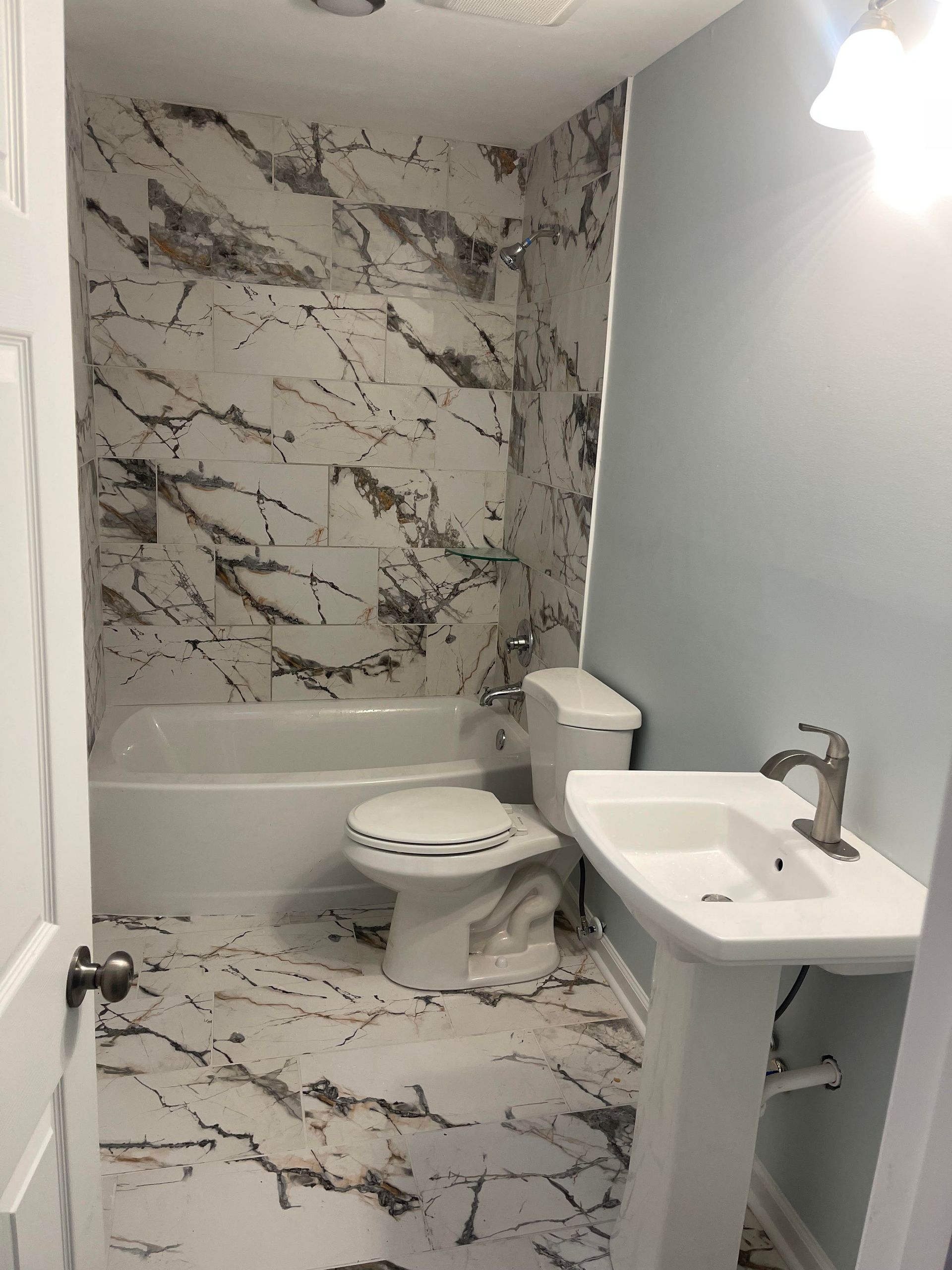 A bathroom with a toilet , sink and bathtub.