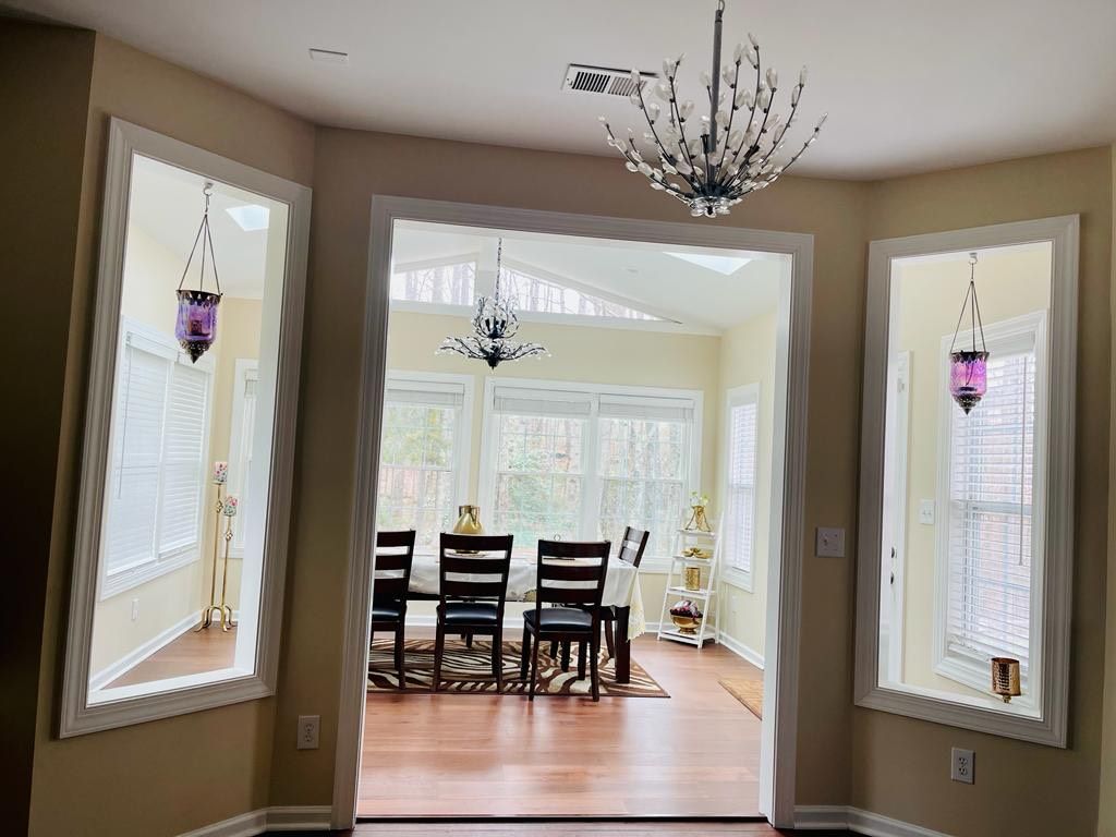 A dining room with a table and chairs and a chandelier hanging from the ceiling.
