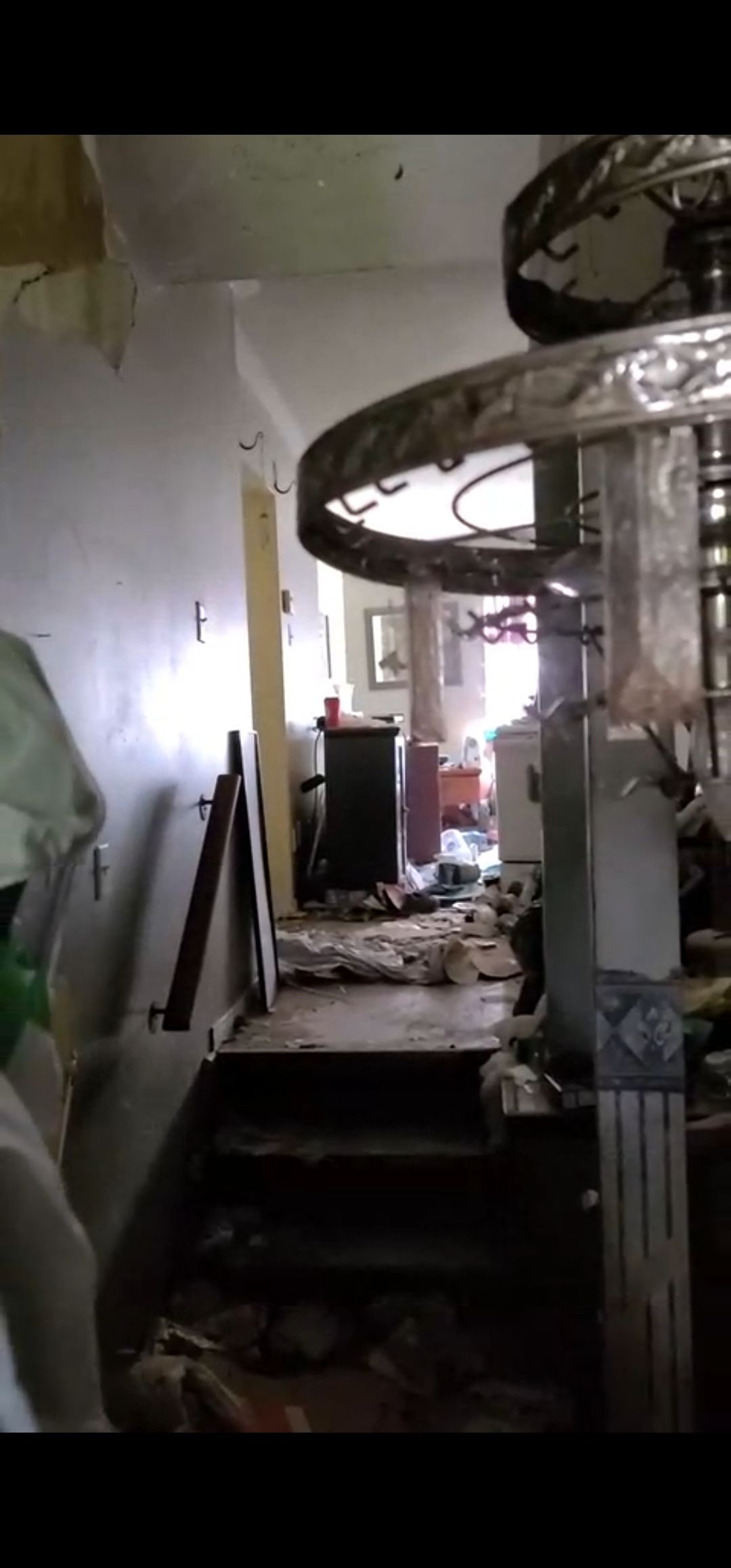 A room with stairs leading up to a ceiling fan.