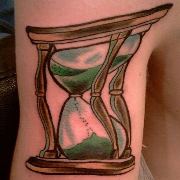 A person has a tattoo of an hourglass on their leg
