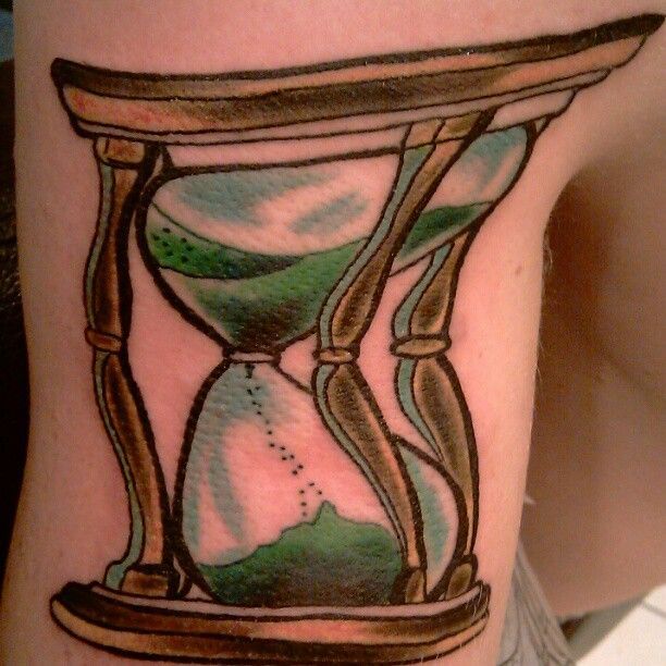 A person has a tattoo of an hourglass on their arm