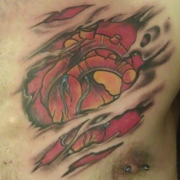 A man has a tattoo of a heart on his chest