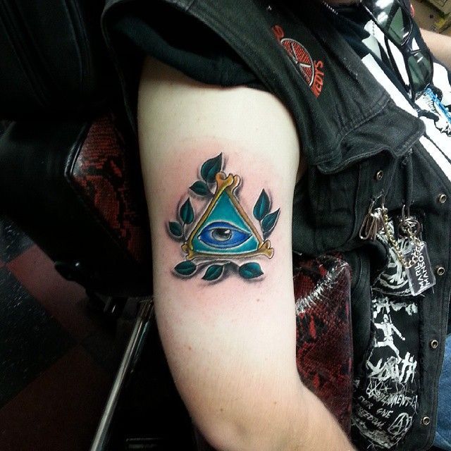 A man has an all seeing eye tattoo on his arm
