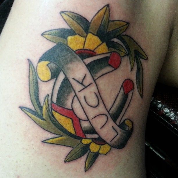 A tattoo of a horseshoe with the word luck written on it