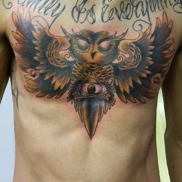 A man has a tattoo of an owl on his chest