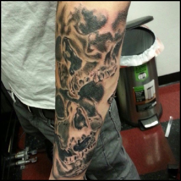 A man has a tattoo of skulls on his arm