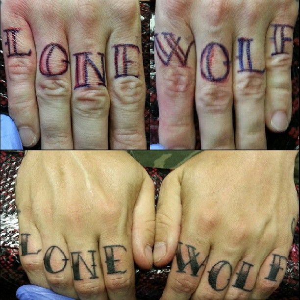 A person has the word lonewolf tattooed on their fingers