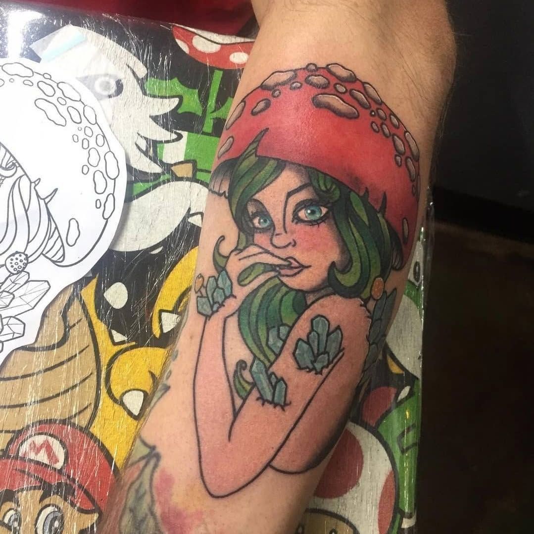 A tattoo of a woman wearing a mushroom hat