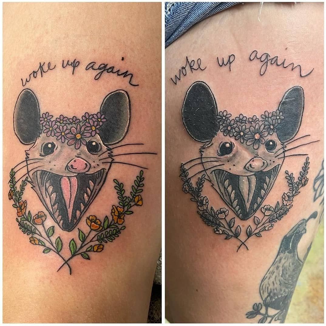 A tattoo of an opossum with the words woke up again
