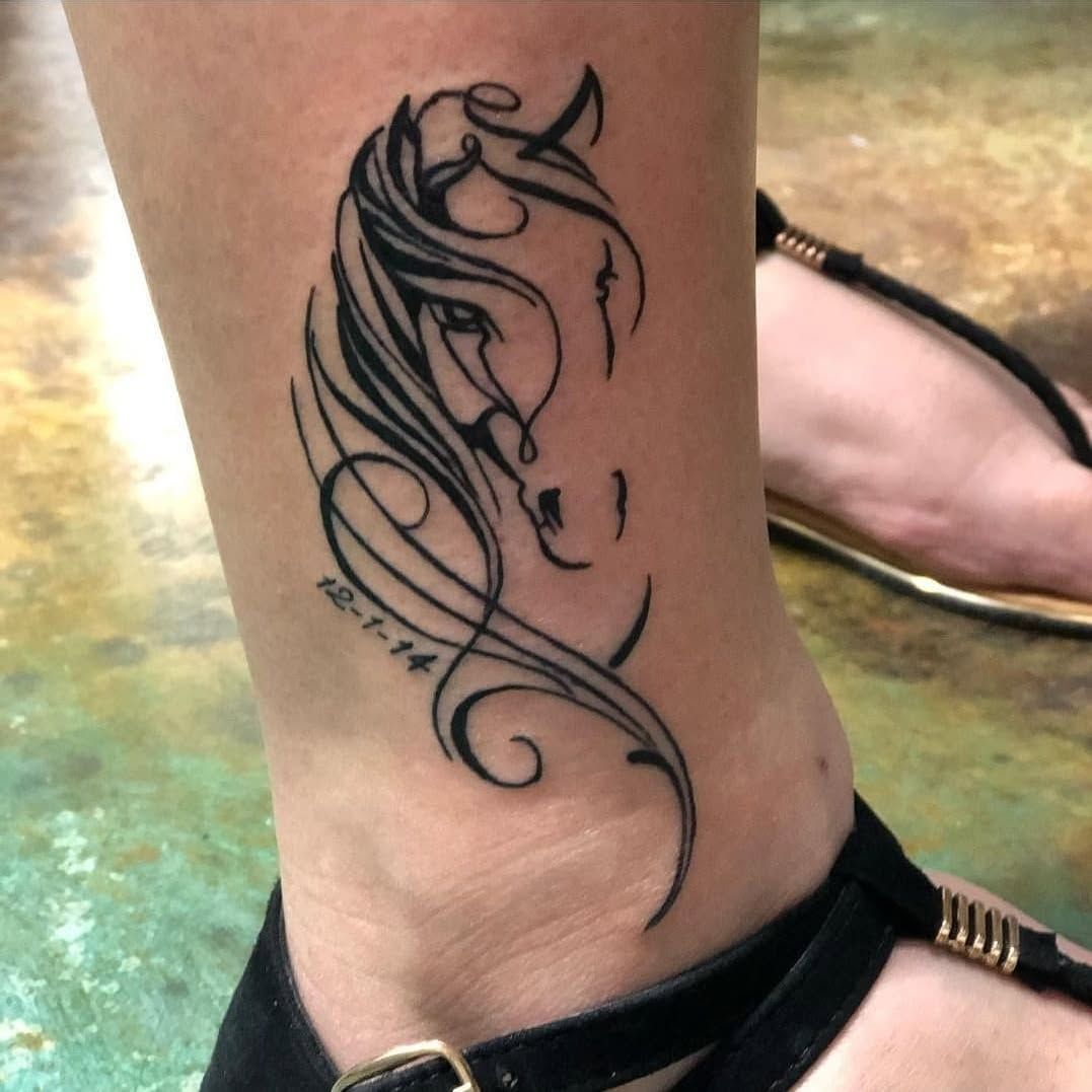 A woman has a tattoo of a horse on her ankle