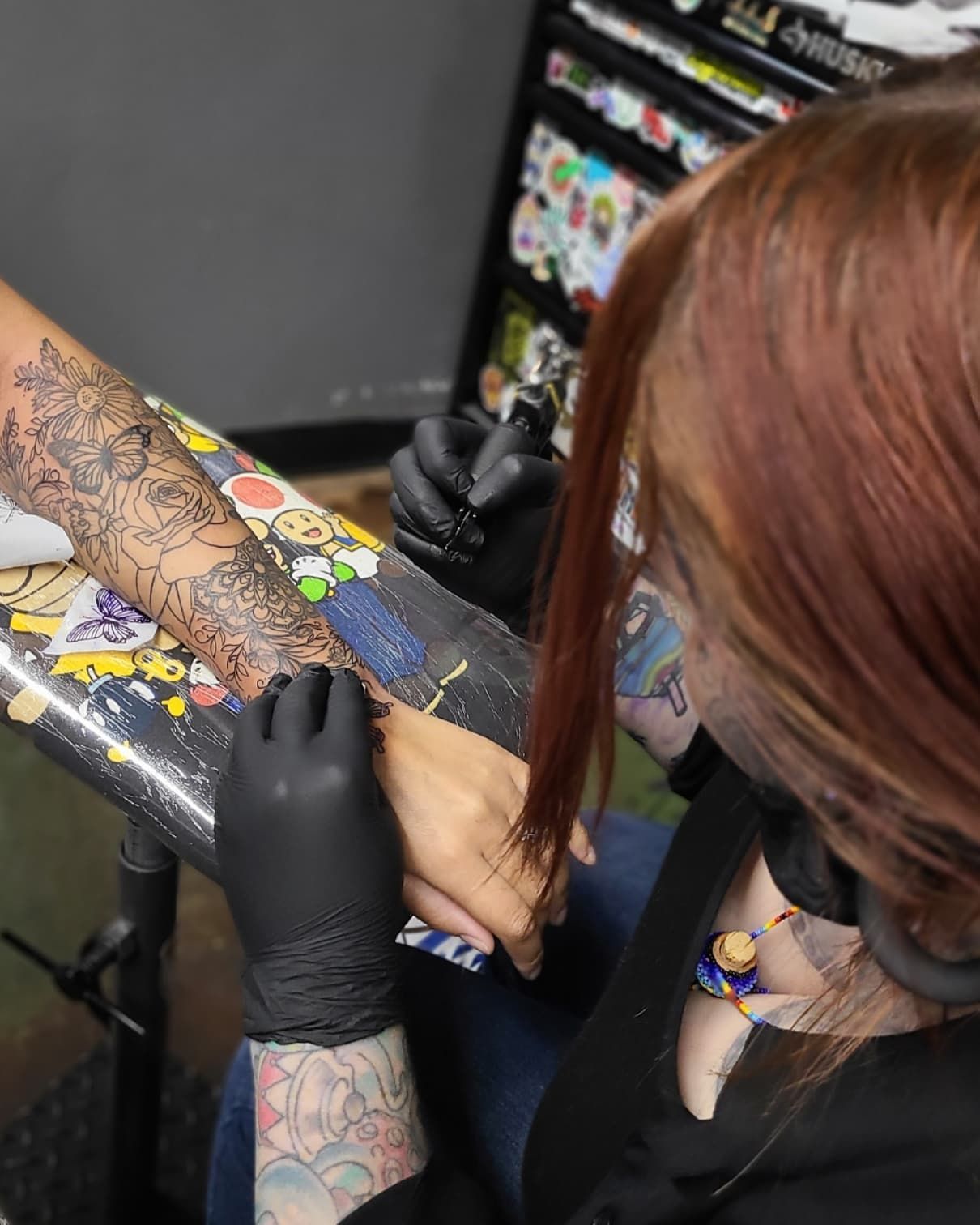 A woman is getting a tattoo on her arm