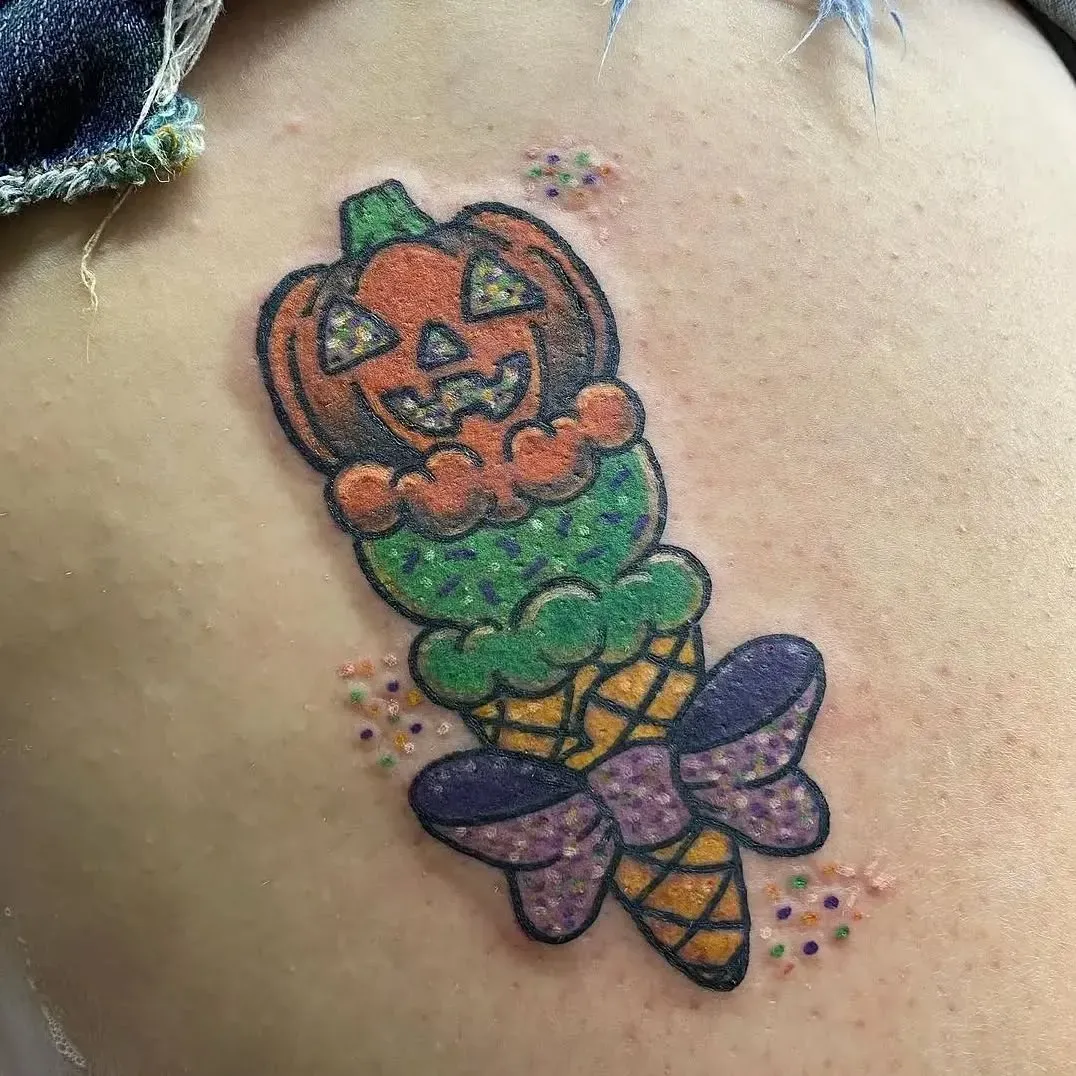 A tattoo of a pumpkin in an ice cream cone on a person 's back.