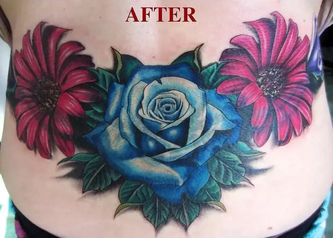 A woman has a blue rose and red flowers tattooed on her back