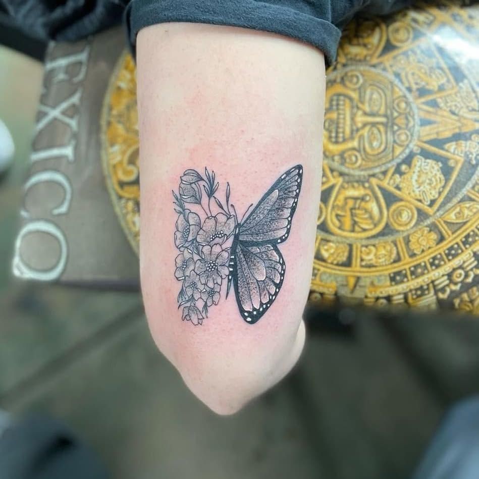A person has a tattoo of a butterfly on their arm