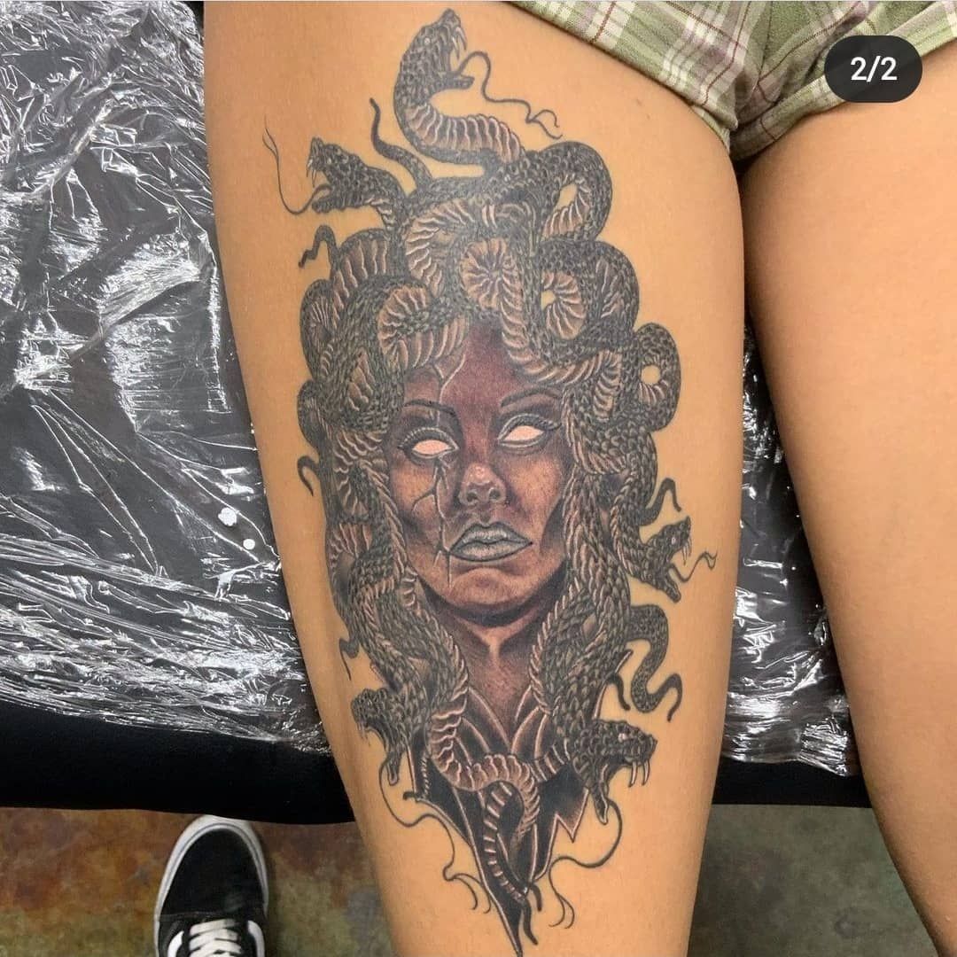 A woman has a medusa tattoo on her leg