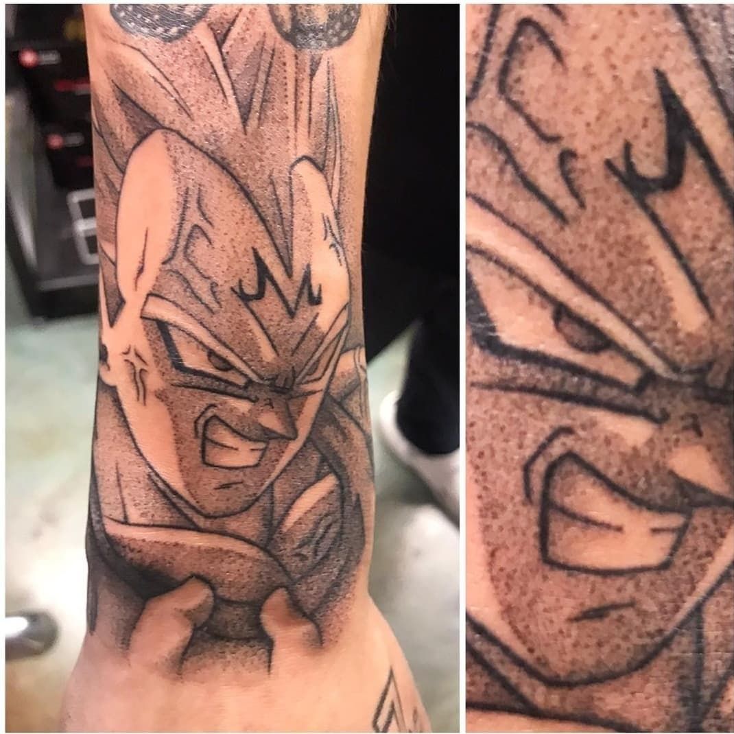 A man has a tattoo of a dragon ball character on his wrist