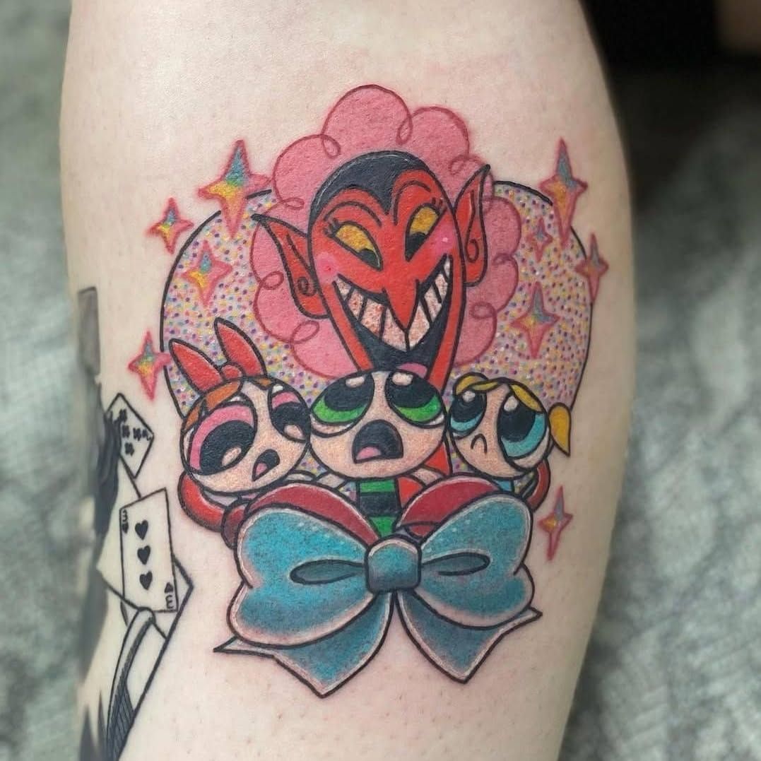 A person has a tattoo of the powerpuff girls on their leg.