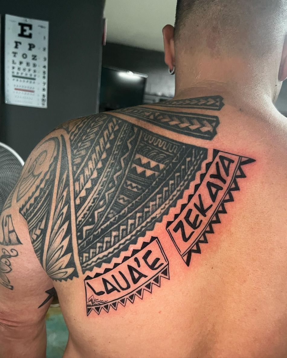 A man has a tattoo on his back that says zekaya