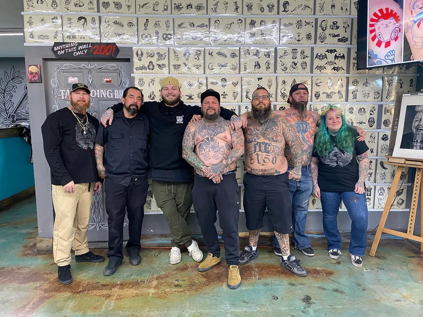 A group of men with tattoos are posing for a picture in a room.