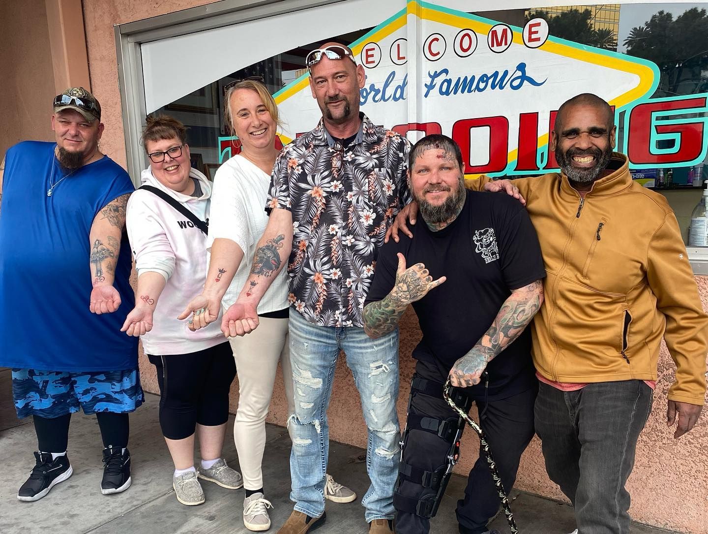 A group of people posing for a picture in front of a sign that says welcome world famous
