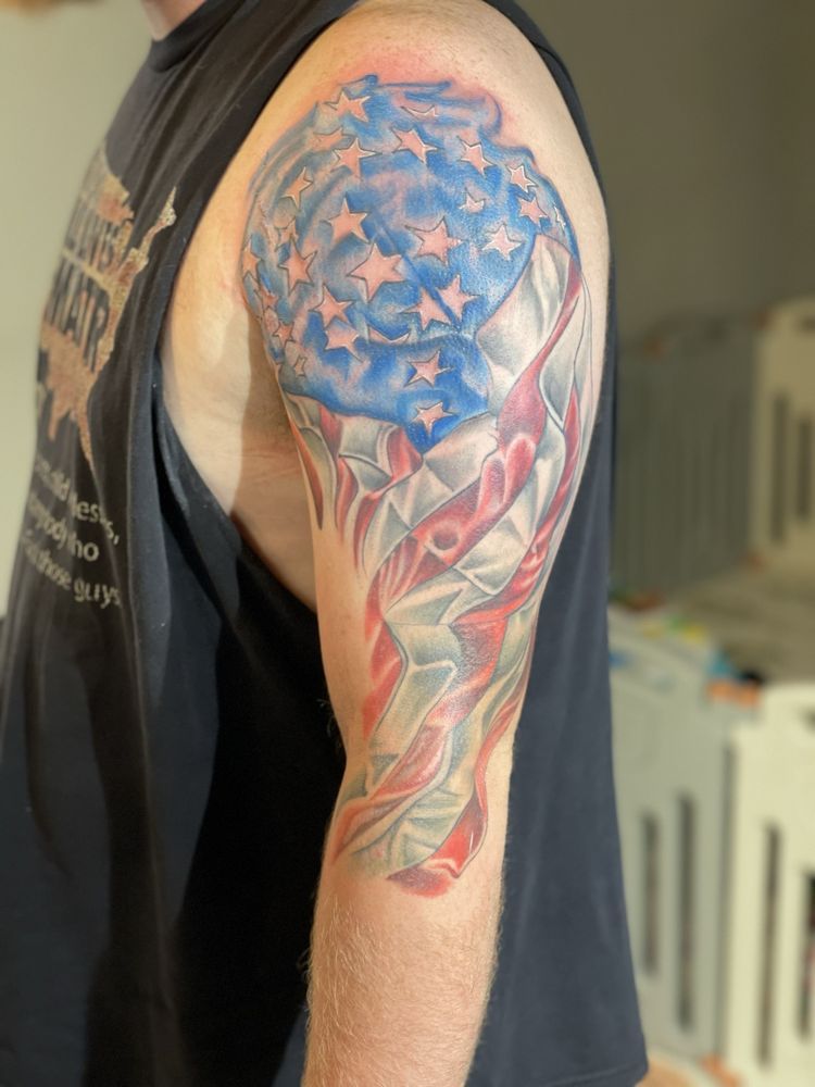 A man has an american flag tattoo on his arm