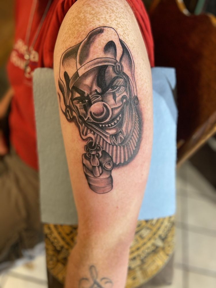 A person has a tattoo of a clown on their arm