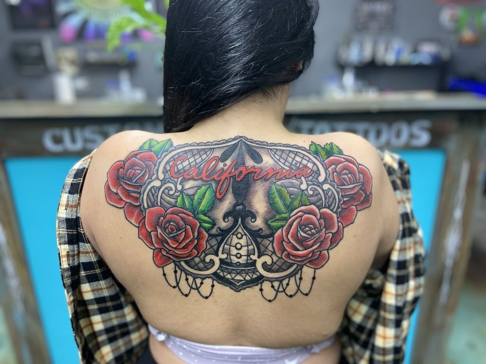 A woman has a tattoo on her back of a skull and roses.