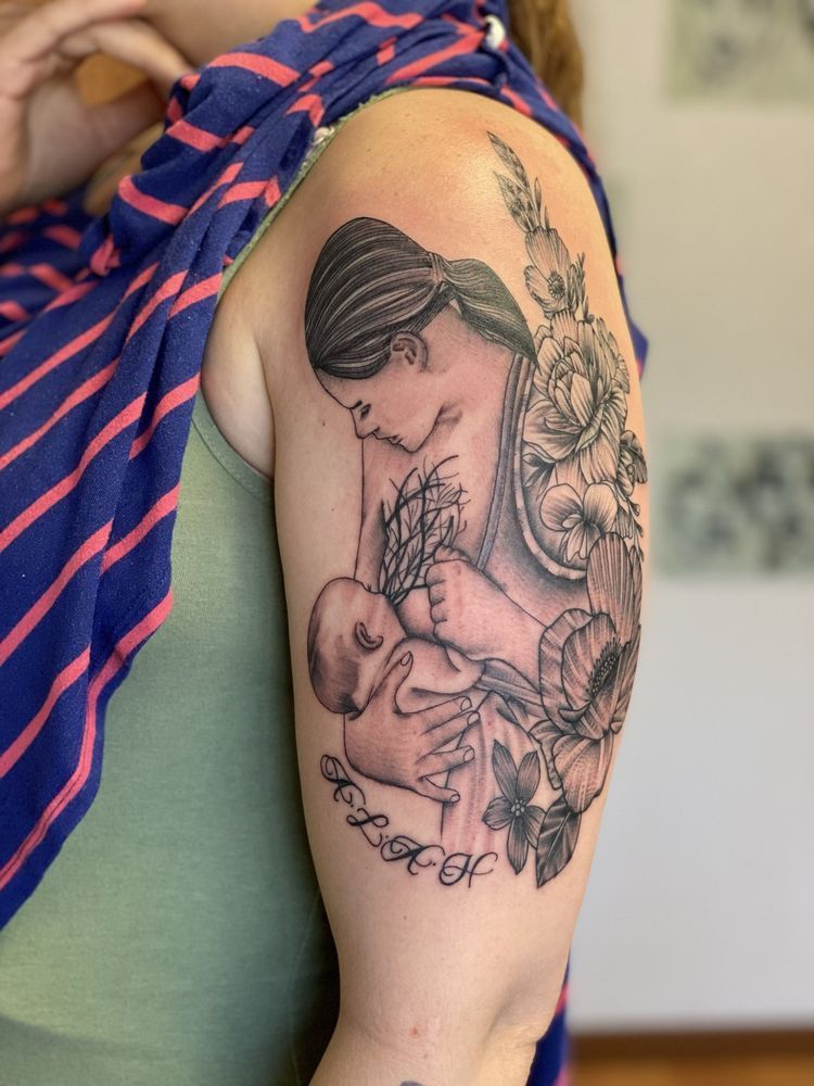 A woman with a tattoo of a woman breastfeeding a baby