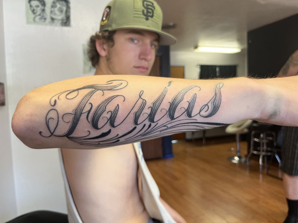 A man has a tattoo on his arm that says farlas