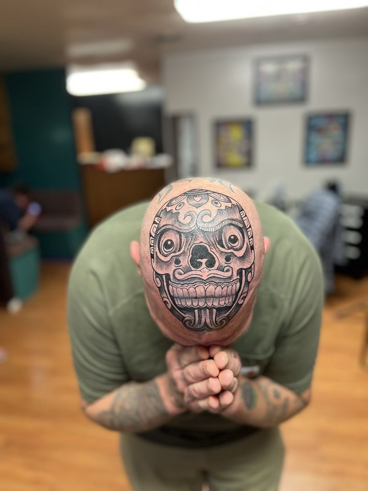 A man with a tattoo of a skull on his head.