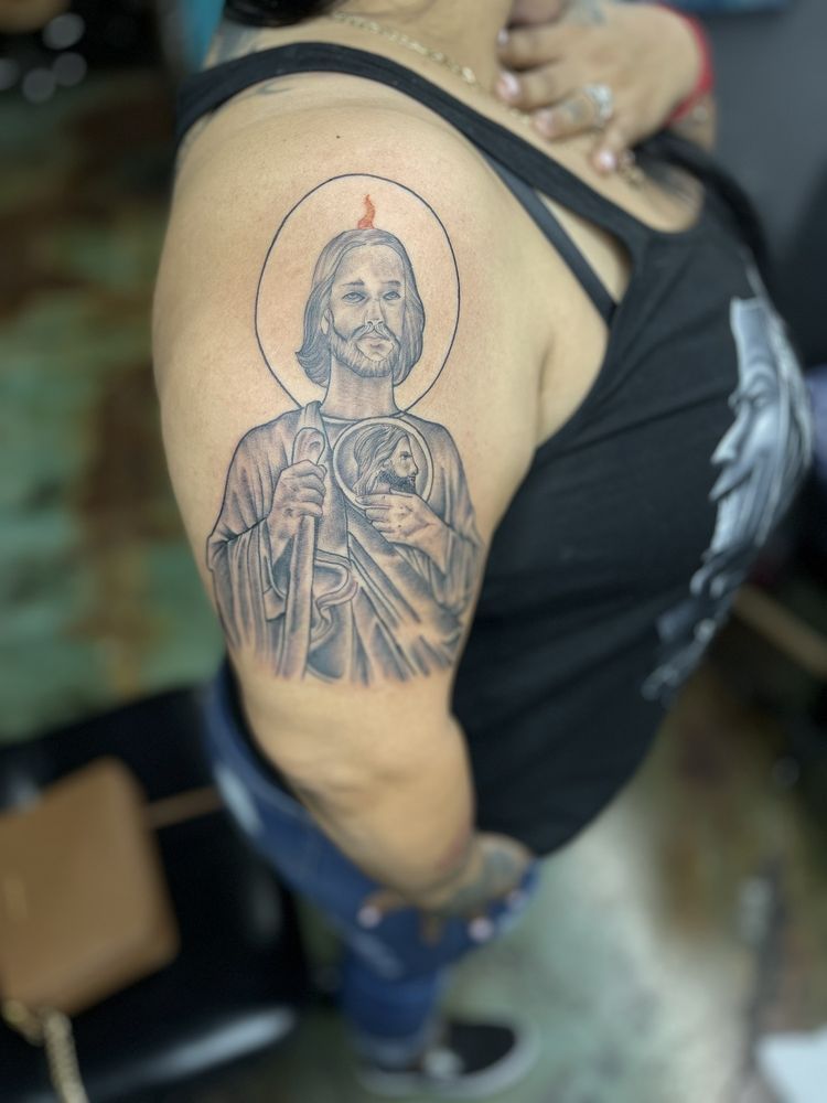 A woman has a tattoo of jesus on her arm