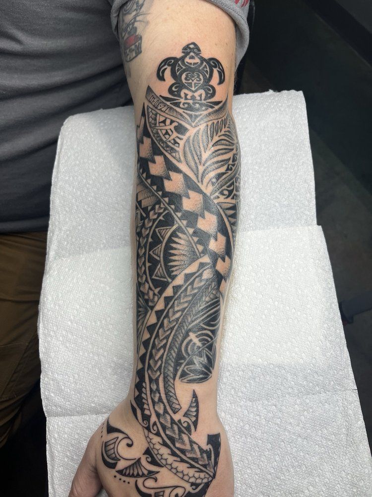 A man 's arm with a tattoo of a turtle on it