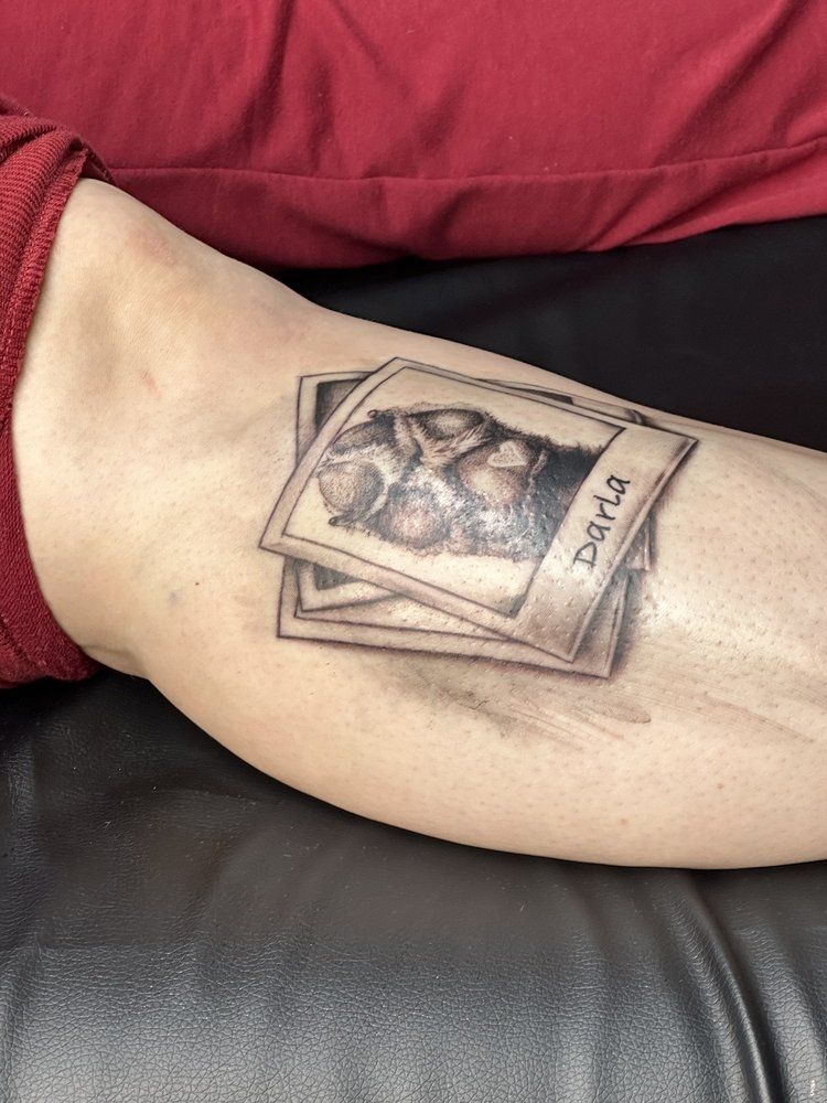 A person has a tattoo of a stack of photos on their arm.