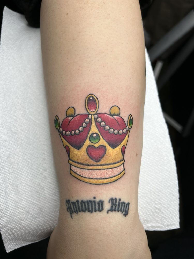 A tattoo of a crown and the name antonio ring