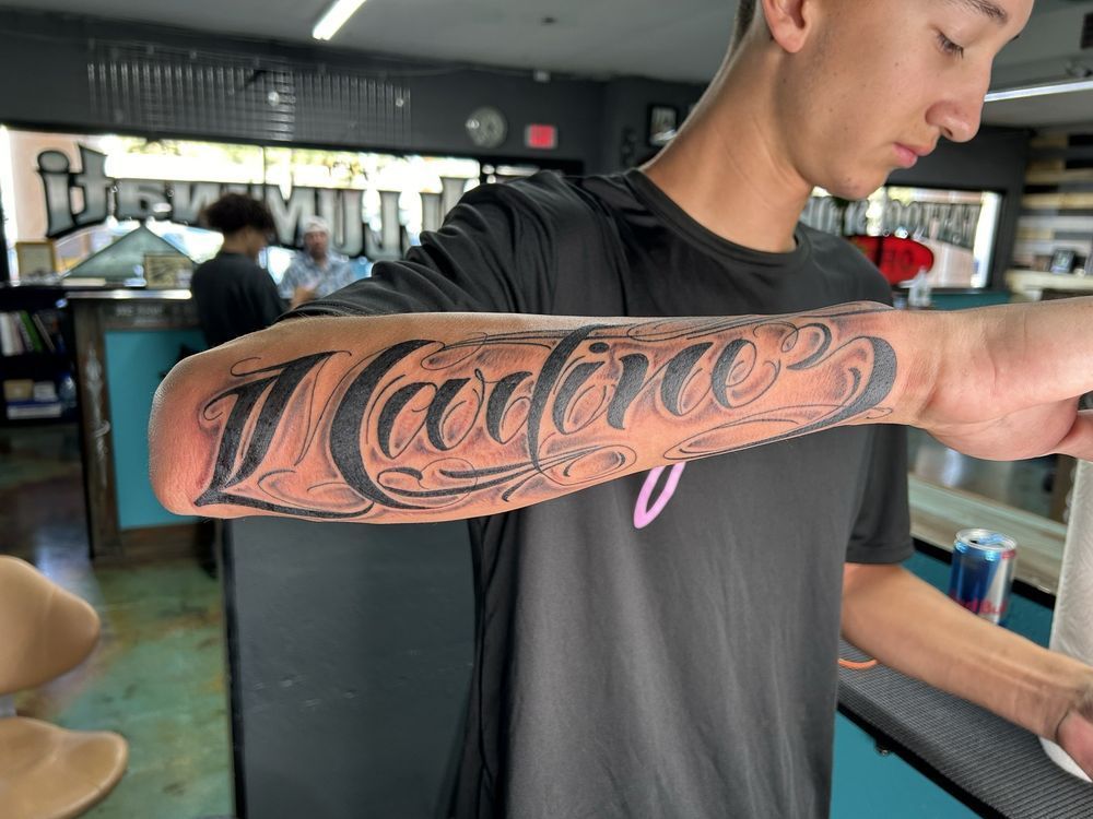 A man has a tattoo on his arm that says marines