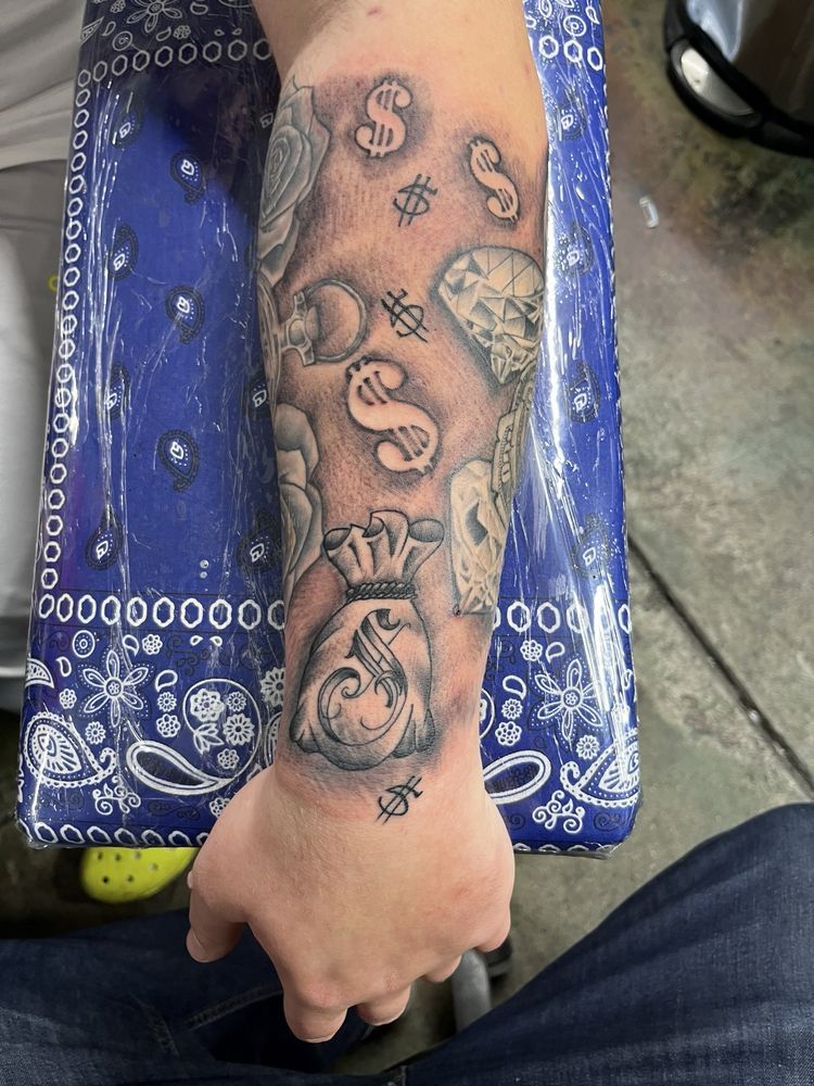 A person has a tattoo on their arm that says money
