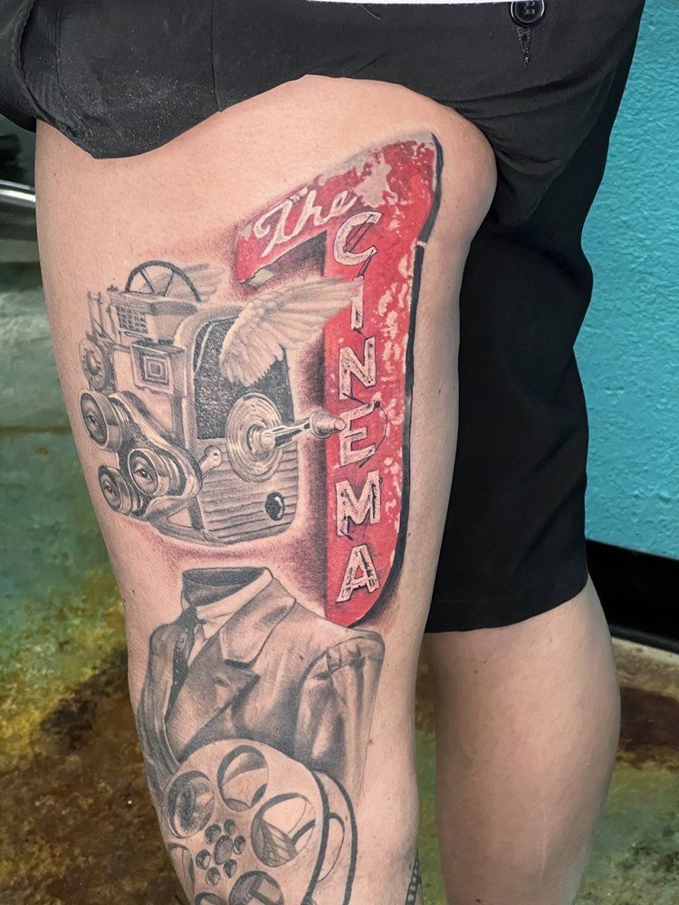 A person with a tattoo on their leg that says the cinema