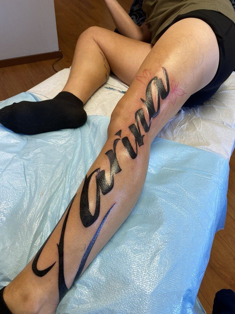 A woman has a tattoo on her leg that says carina
