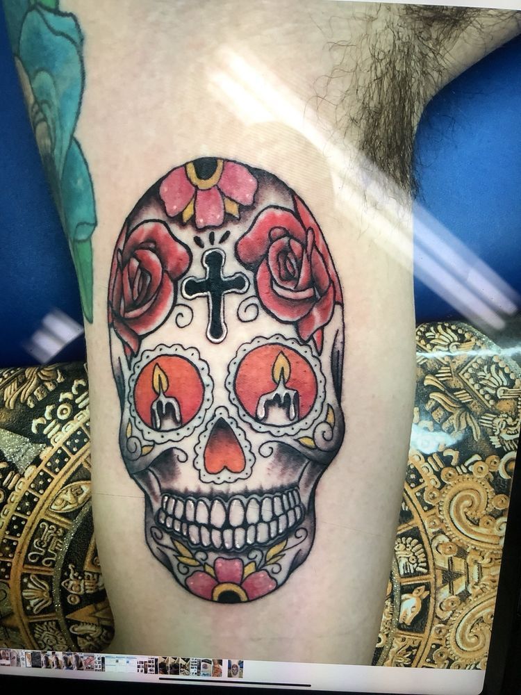 A sugar skull with candles and roses on it