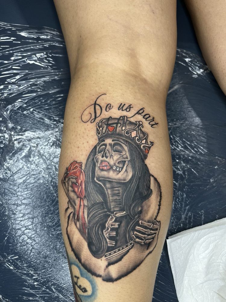 A woman has a tattoo of a skeleton wearing a crown on her leg