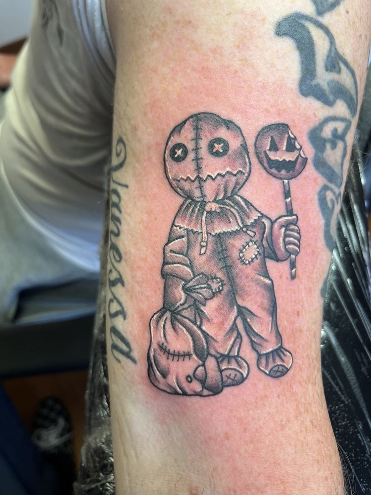 A person has a scarecrow tattoo on their arm