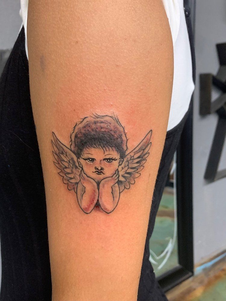 A person has a tattoo of an angel on their arm.