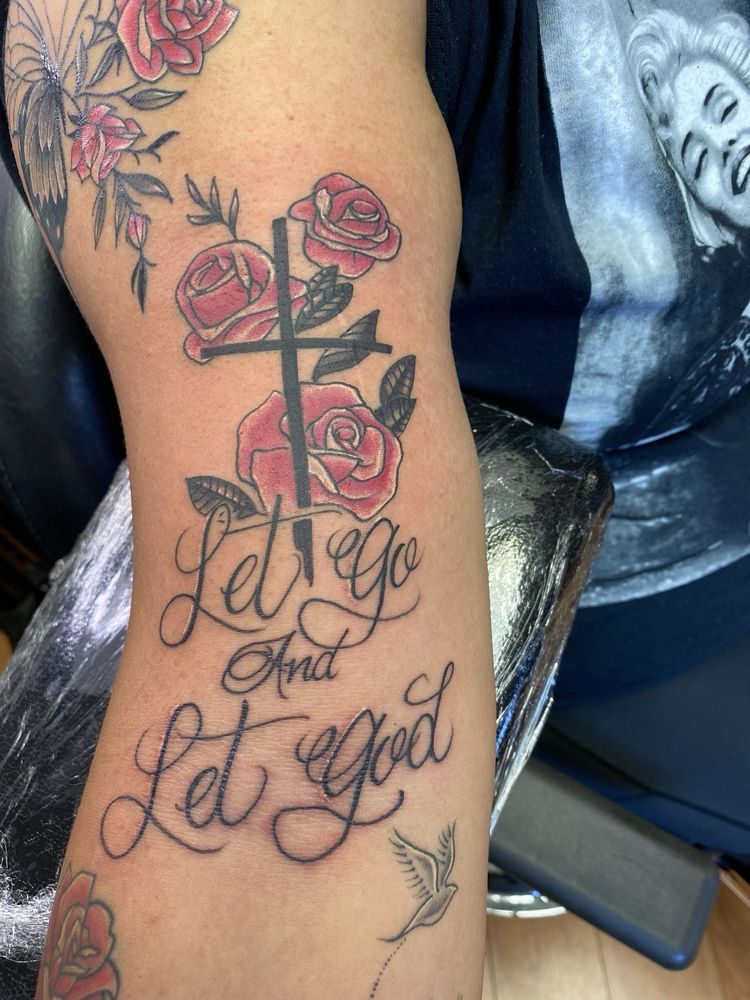 A woman has a tattoo on her arm that says let go and let god