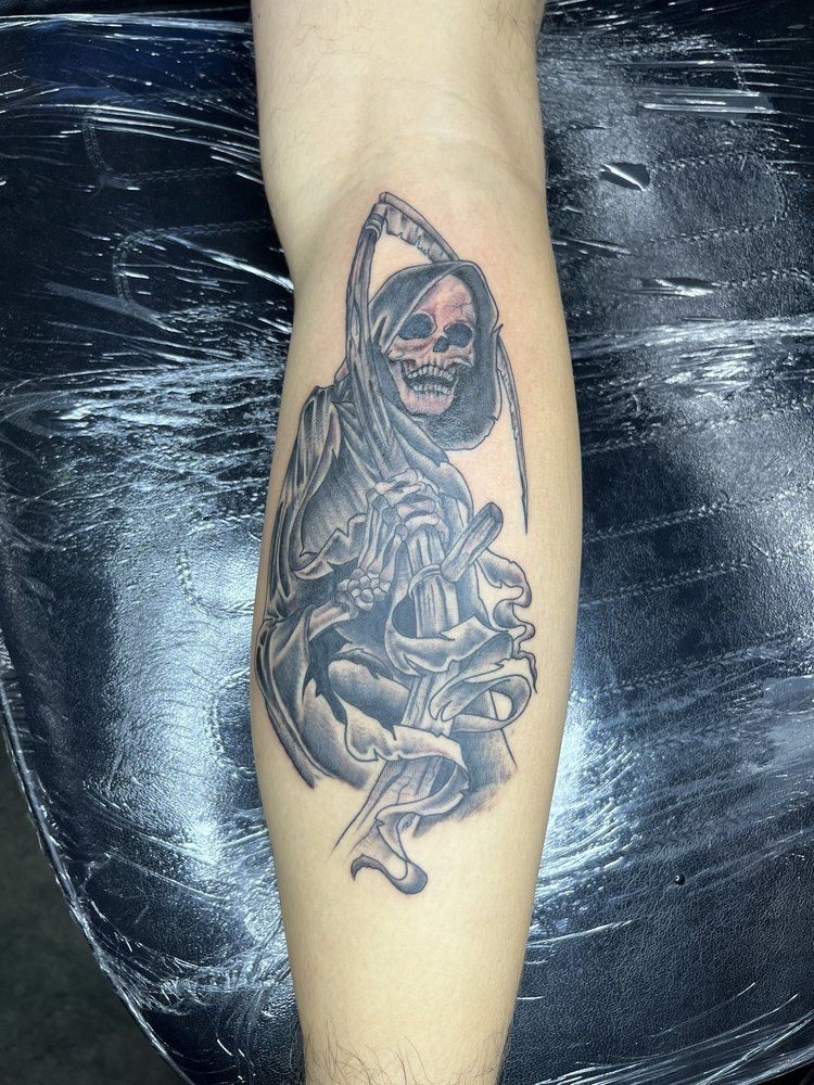 A grim reaper tattoo on a person 's leg
