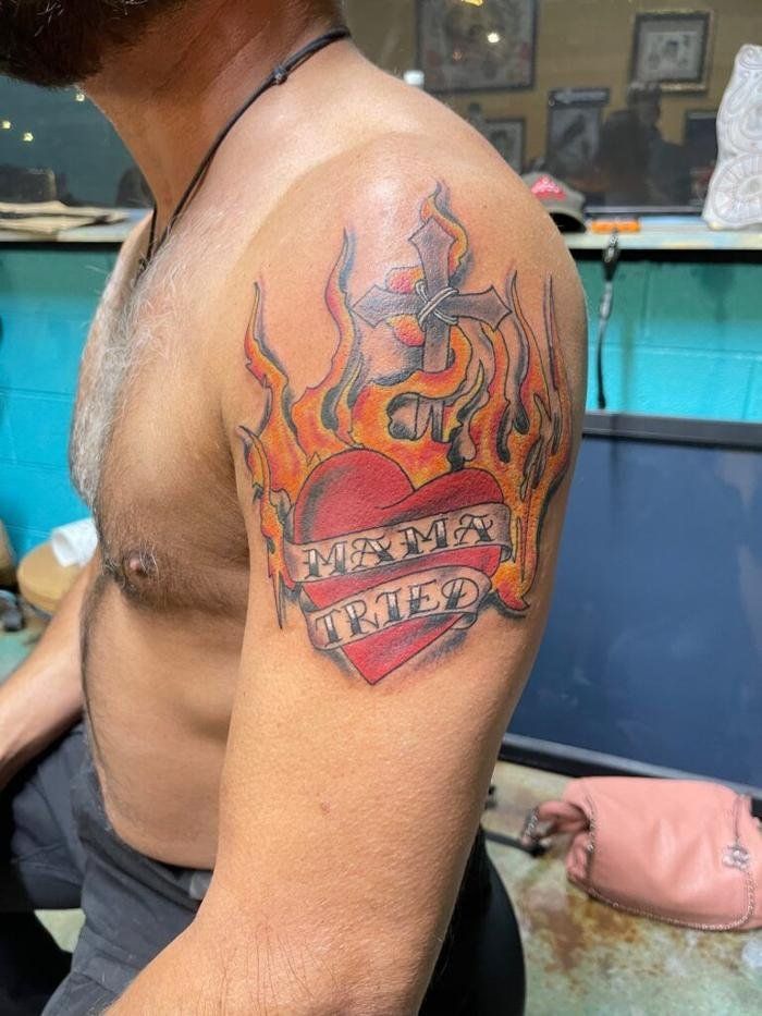 A man has a tattoo of a heart on his arm