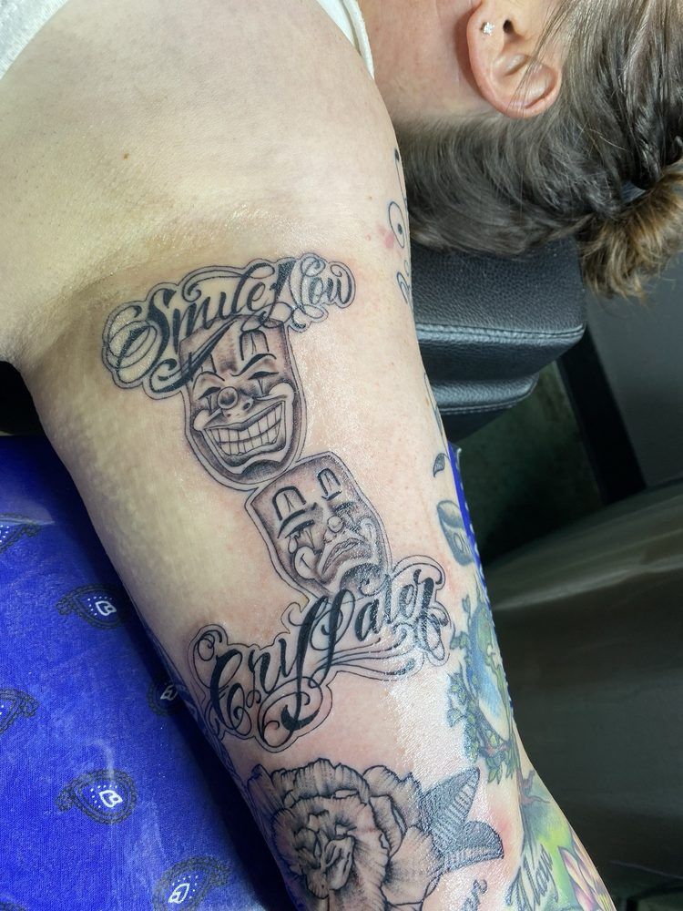 A woman is getting a tattoo on her arm.