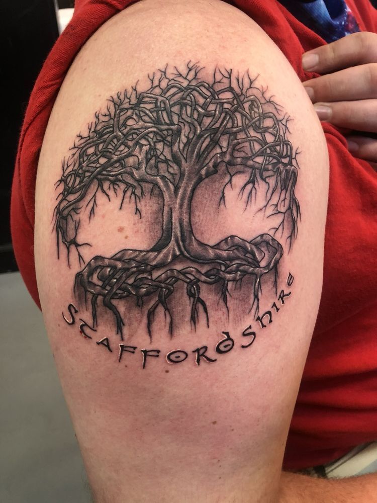 A person has a tattoo of a tree on their arm